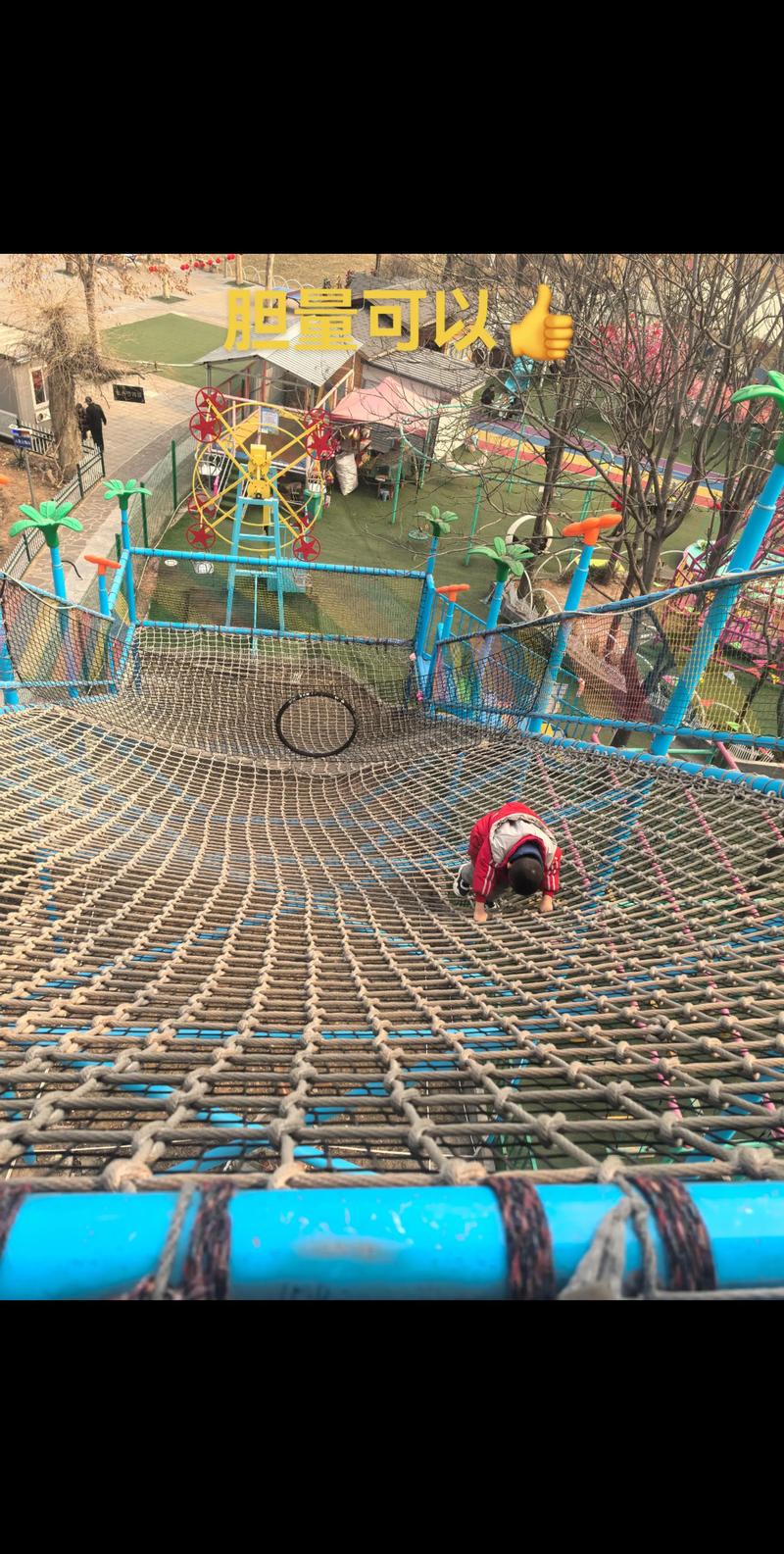游乐场里孩子攀爬架妈妈在旁担心的场景