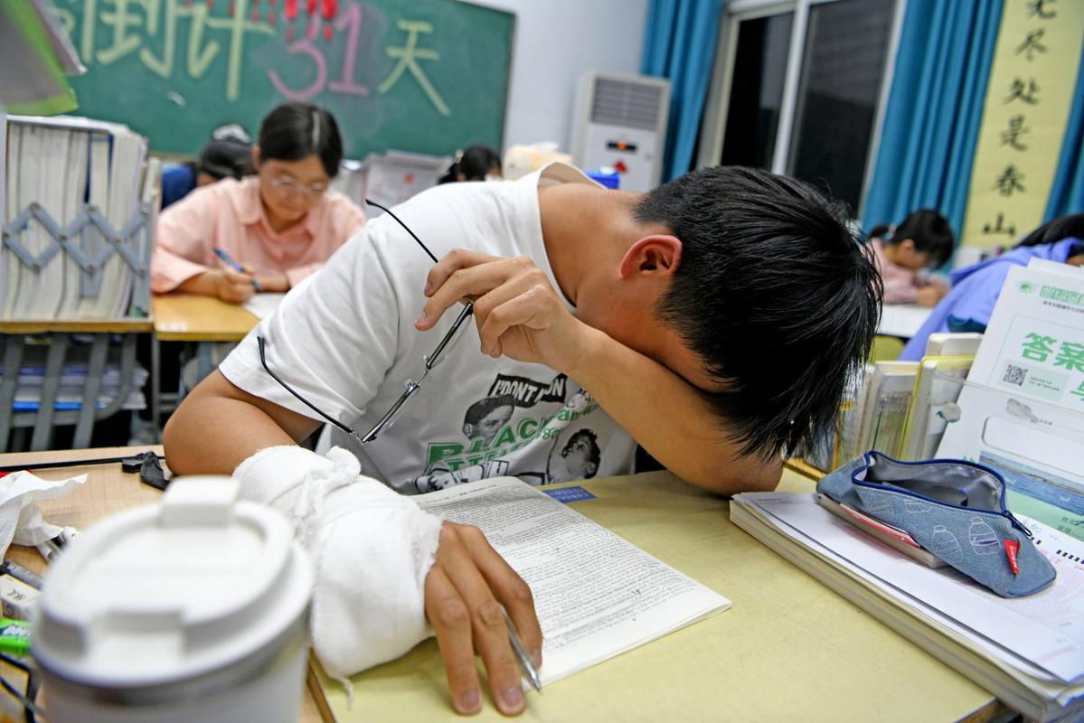 学生深夜在教室外面哭泣，手里拿着试卷