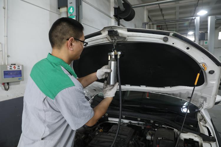 汽修师傅听诊汽车喷油嘴工作现场图