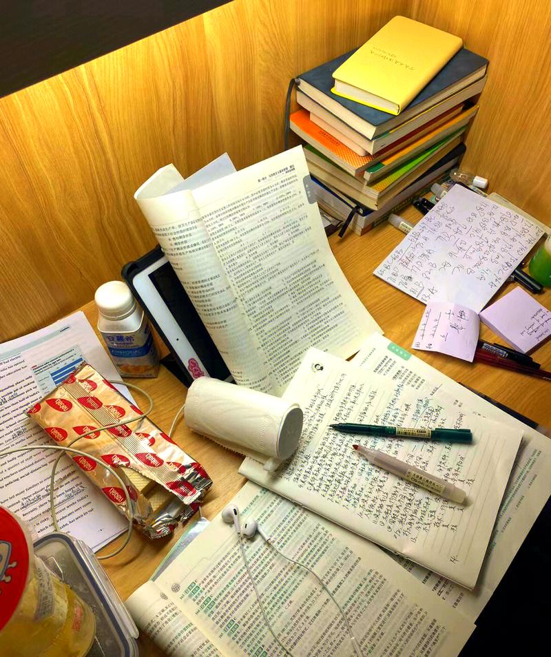 考研自习室堆满笔记和彩色标签的桌面特写