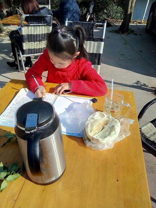 孩子写作业手边放半杯奶茶的书桌实拍
