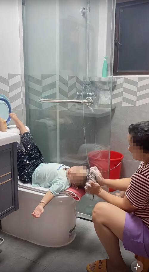 幼儿害怕洗头妈妈抱着安抚的浴室场景