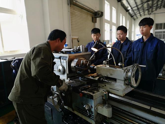 工业车间老师傅带新人加工零件教学照片