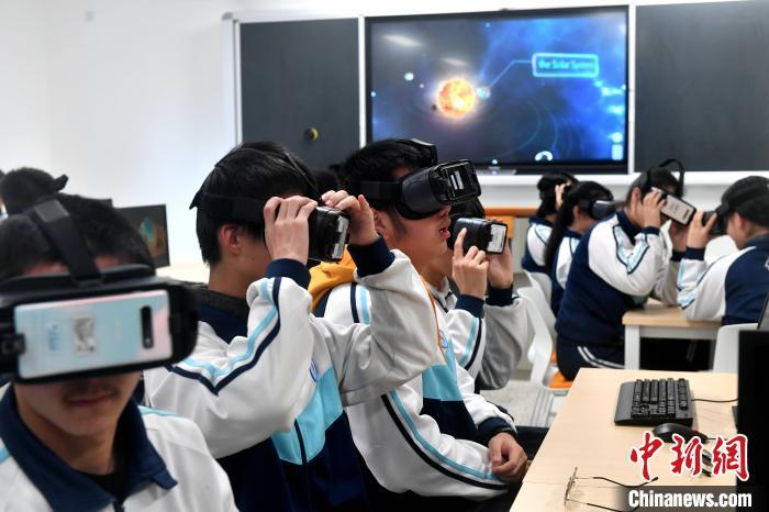 中学生佩戴VR眼镜在元宇宙课堂探索太阳系