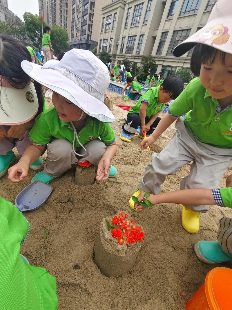 儿童在户外沙坑自由搭建火山