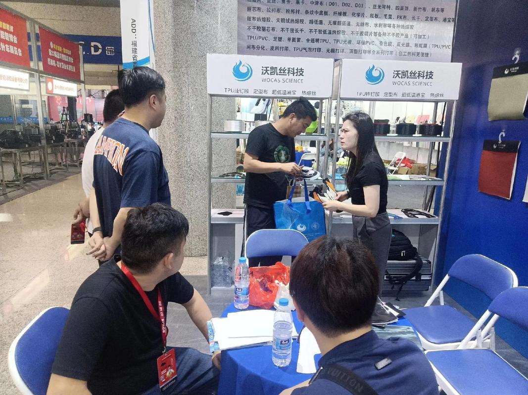 工业展会小型精密零部件展位上摊主与客户交谈