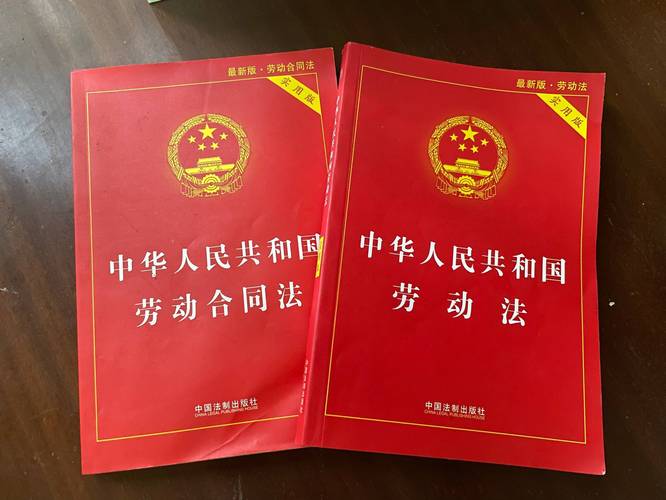 劳动合同签字特写,桌上摆着劳动法书籍