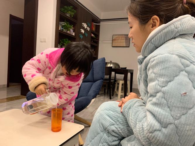 家长陪幼儿收拾打翻水杯场景图