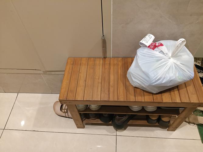 放在玄关换鞋凳上的明黄色外卖餐袋