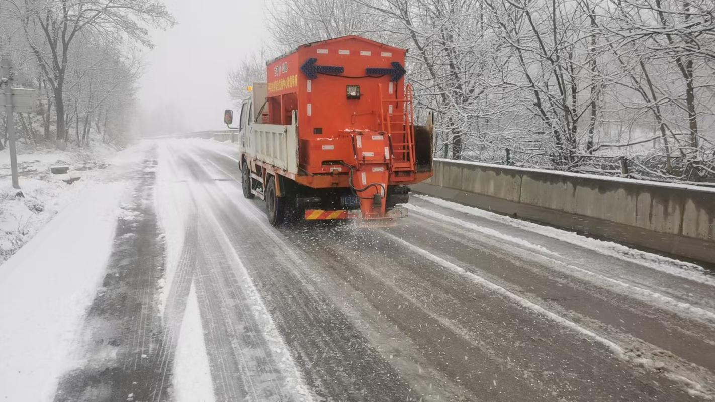 公路融雪撒盐车正在撒布工业盐融雪剂