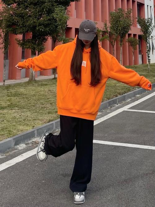 复古墨绿灯芯绒裤搭配亮橙色短款卫衣穿搭图