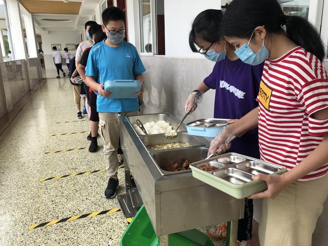 校园宿舍楼下师生递盒饭场景