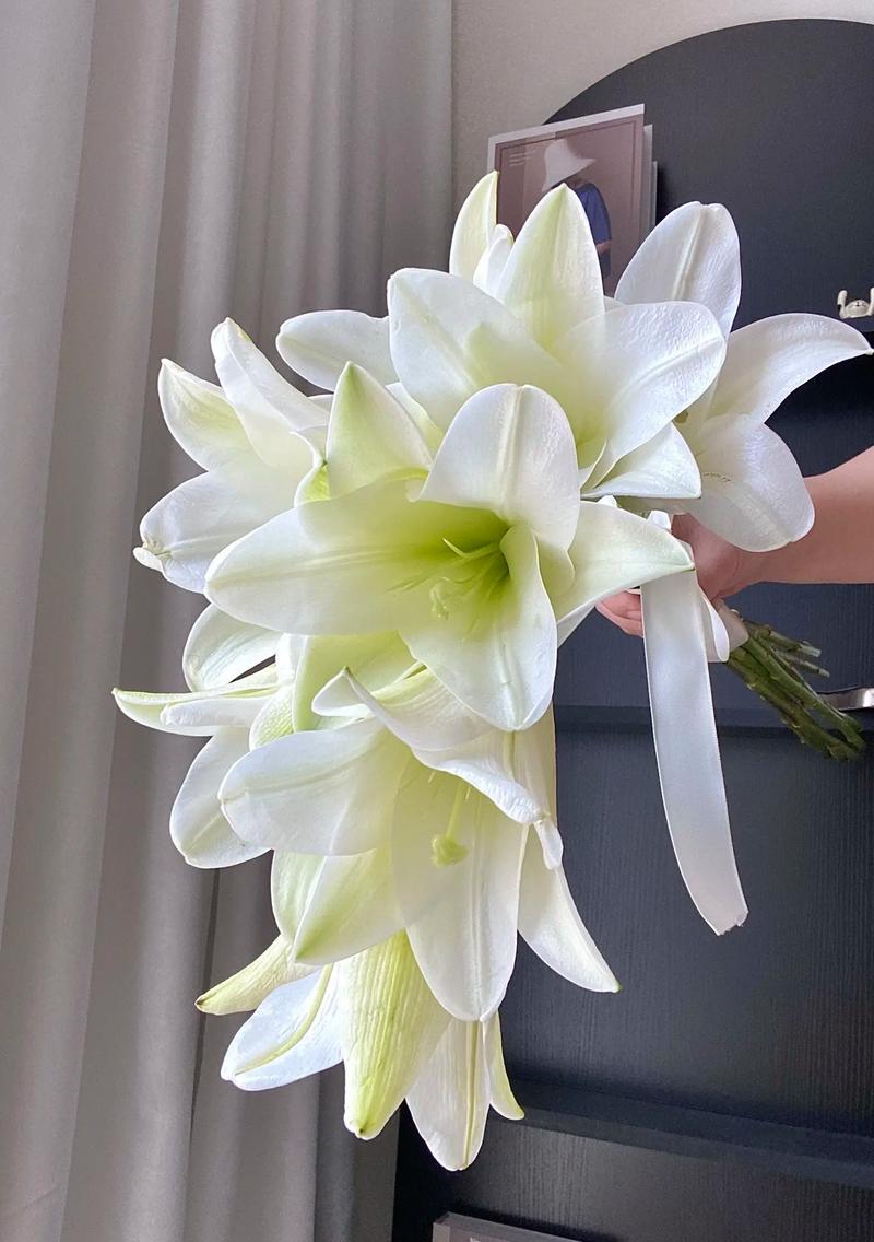 新娘手持一枝白色百合手捧花户外婚礼