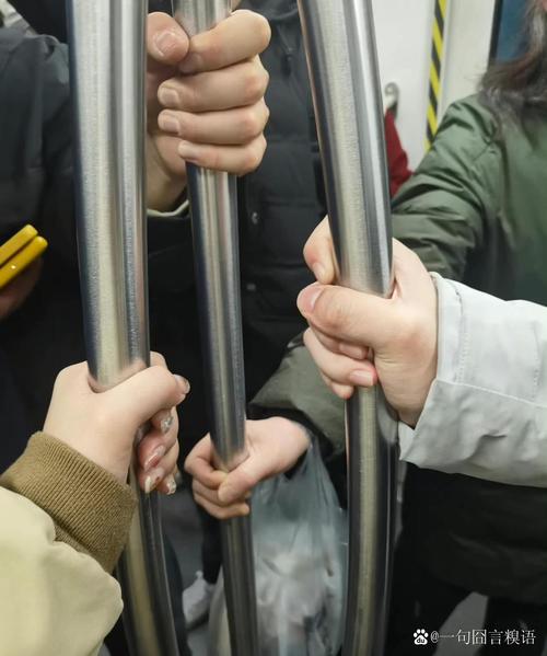 地铁车厢内乘客扶着栏杆保持重心的手部特写