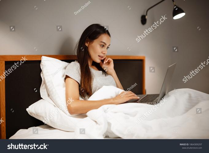 自由职业者早晨在床上用笔记本电脑工作