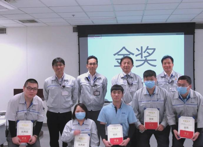 精密汽车零部件车间员工手持勇气证书合影
