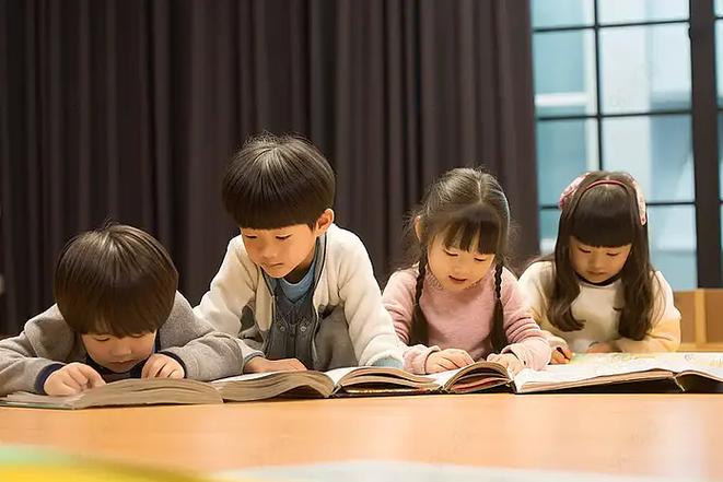 两岁幼儿趴在地毯上翻绘本儿童阅读启蒙场景