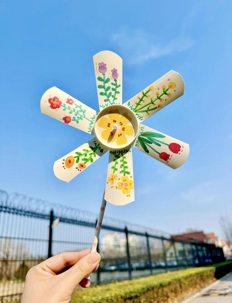 儿童手工制作纸风车的户外亲子活动场景