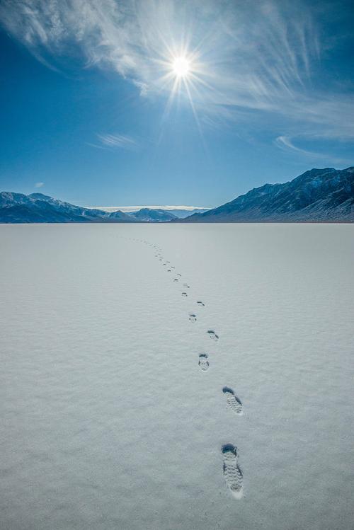 空旷雪地上一双新鲜脚印延伸向远处