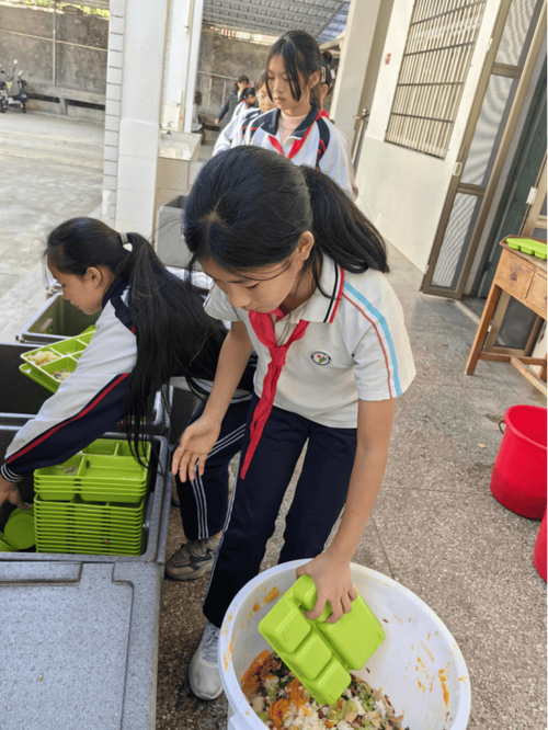 小学生课堂分装厨余垃圾实践场景图