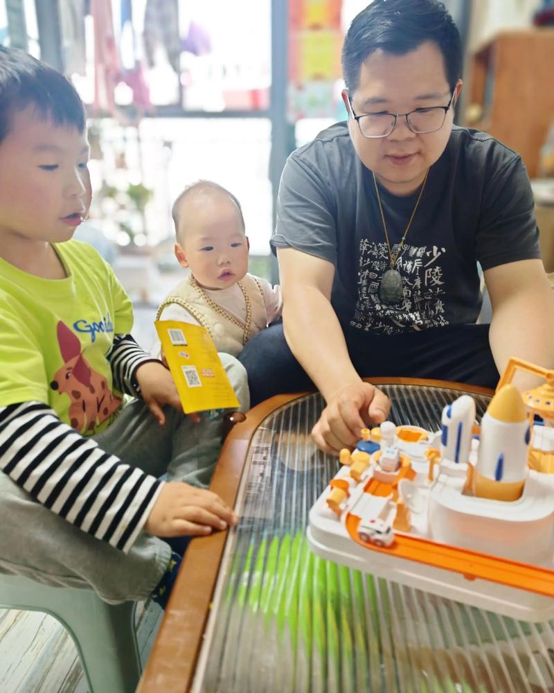 幼儿趴在桌上分辨硬币面额亲子互动实景