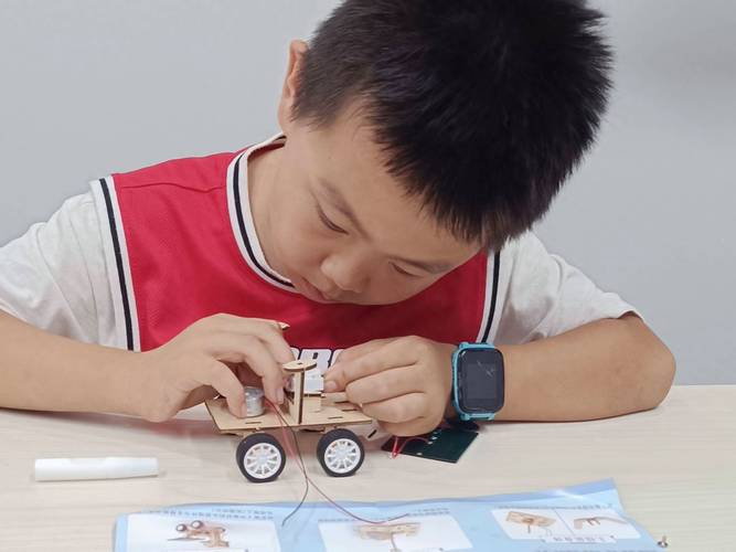 机械工人小学生家长陪孩子做科创比赛作品照片