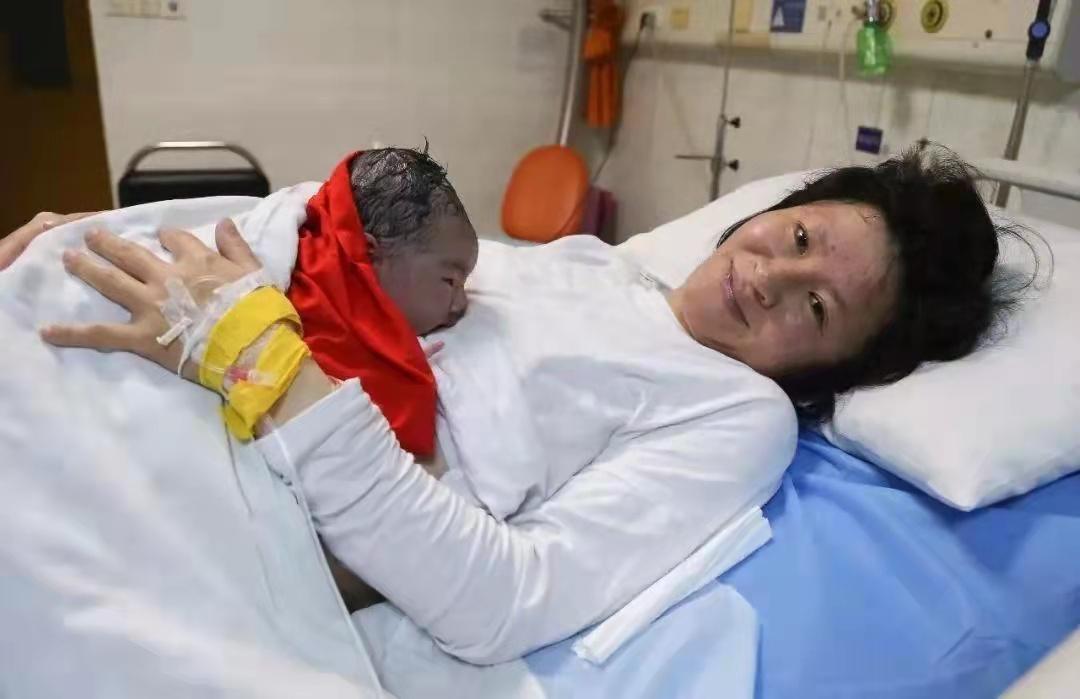 母亲紧紧拥抱新生婴儿肌肤接触