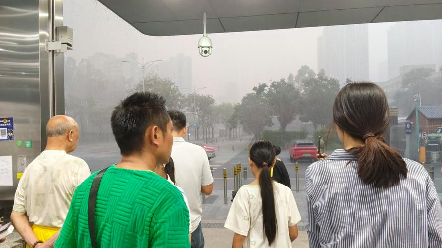 下雨天城市地铁口躲雨的行人