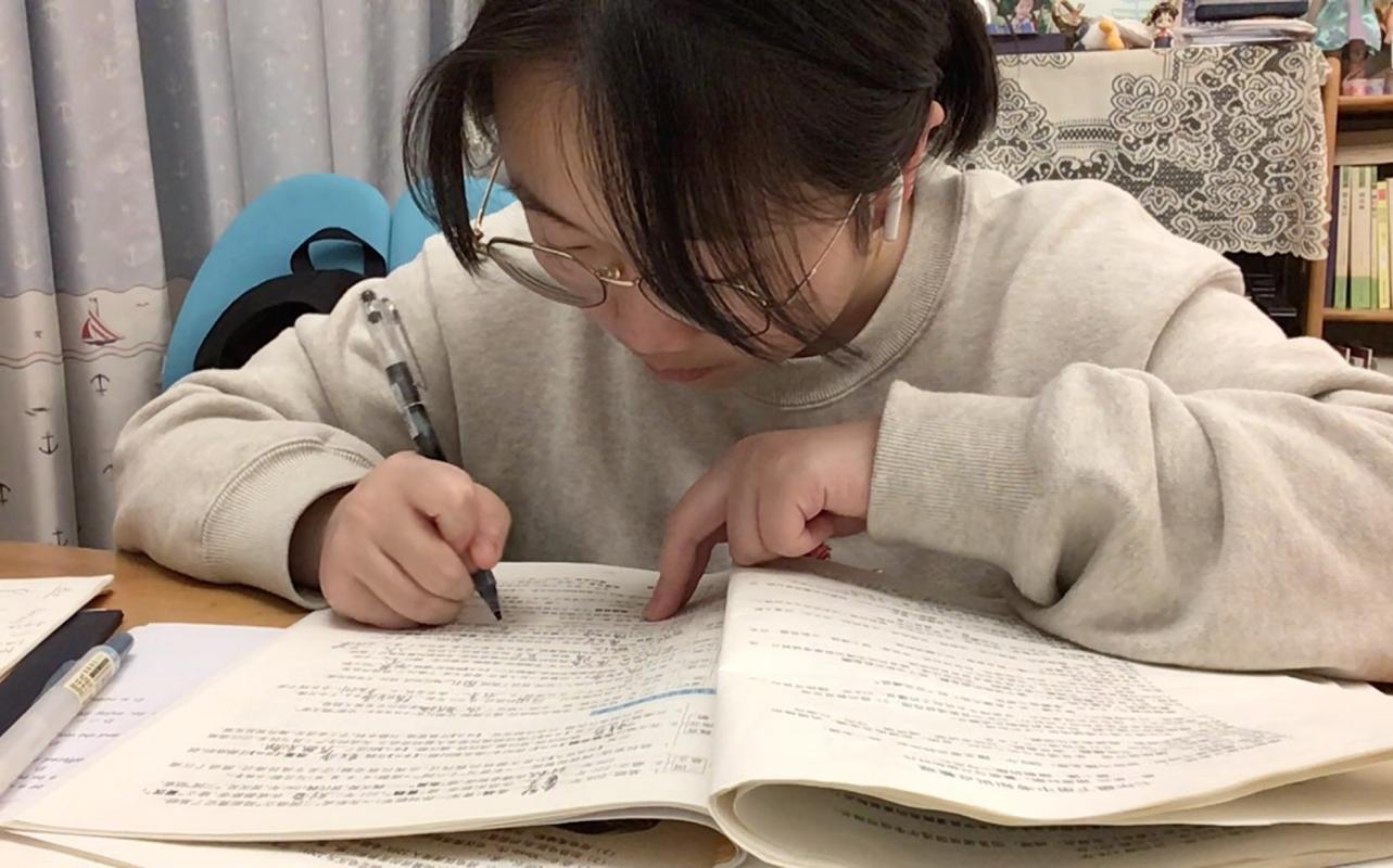 中学课堂上低头认真写笔记的学生特写