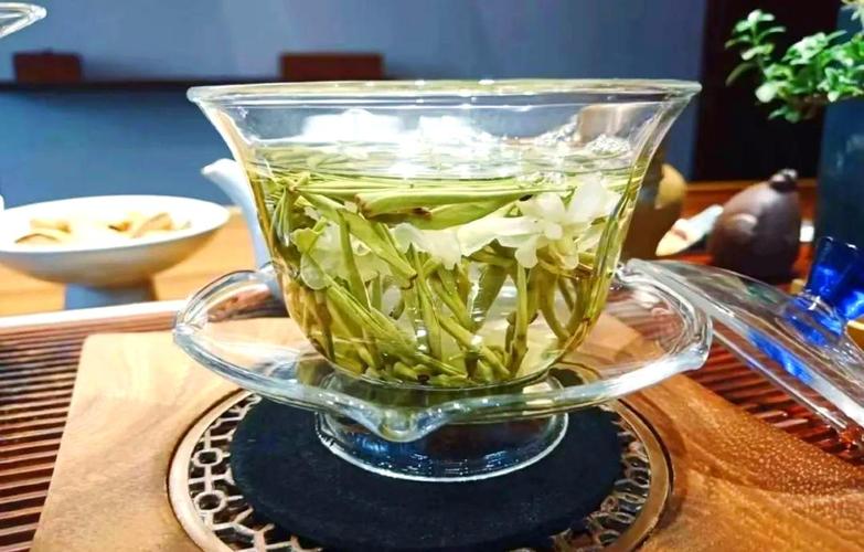 朋友围坐茶桌随意用玻璃杯泡茉莉花茶的松弛场景