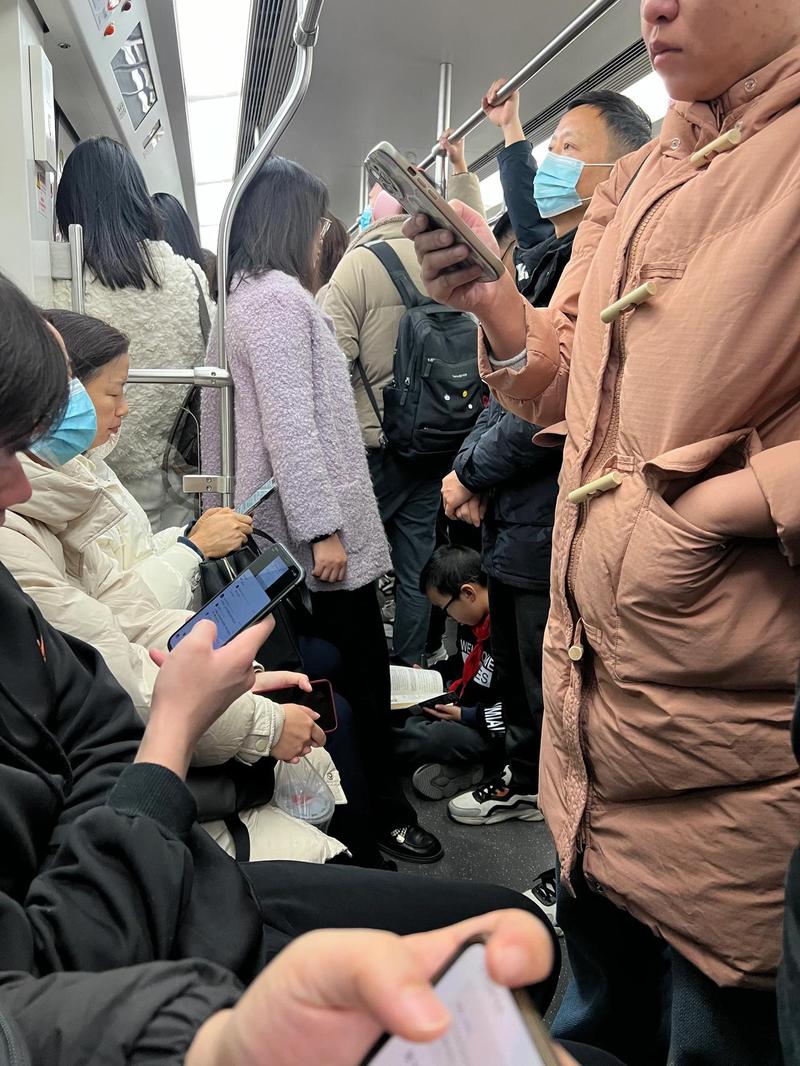地铁车厢内年轻人给带幼儿的妈妈让座的日常场景