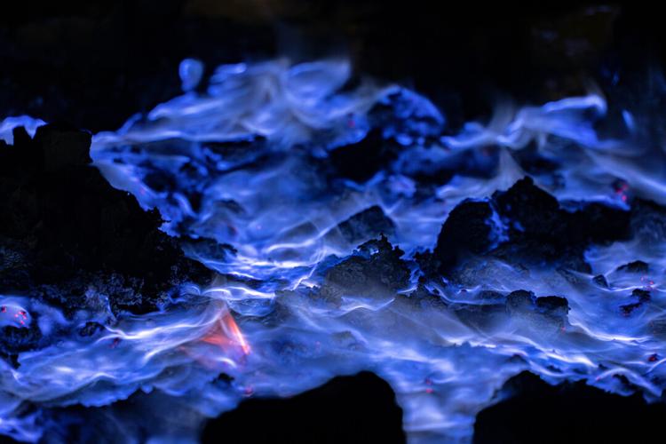 伊真火山口夜幕下燃烧的蓝色硫磺火焰