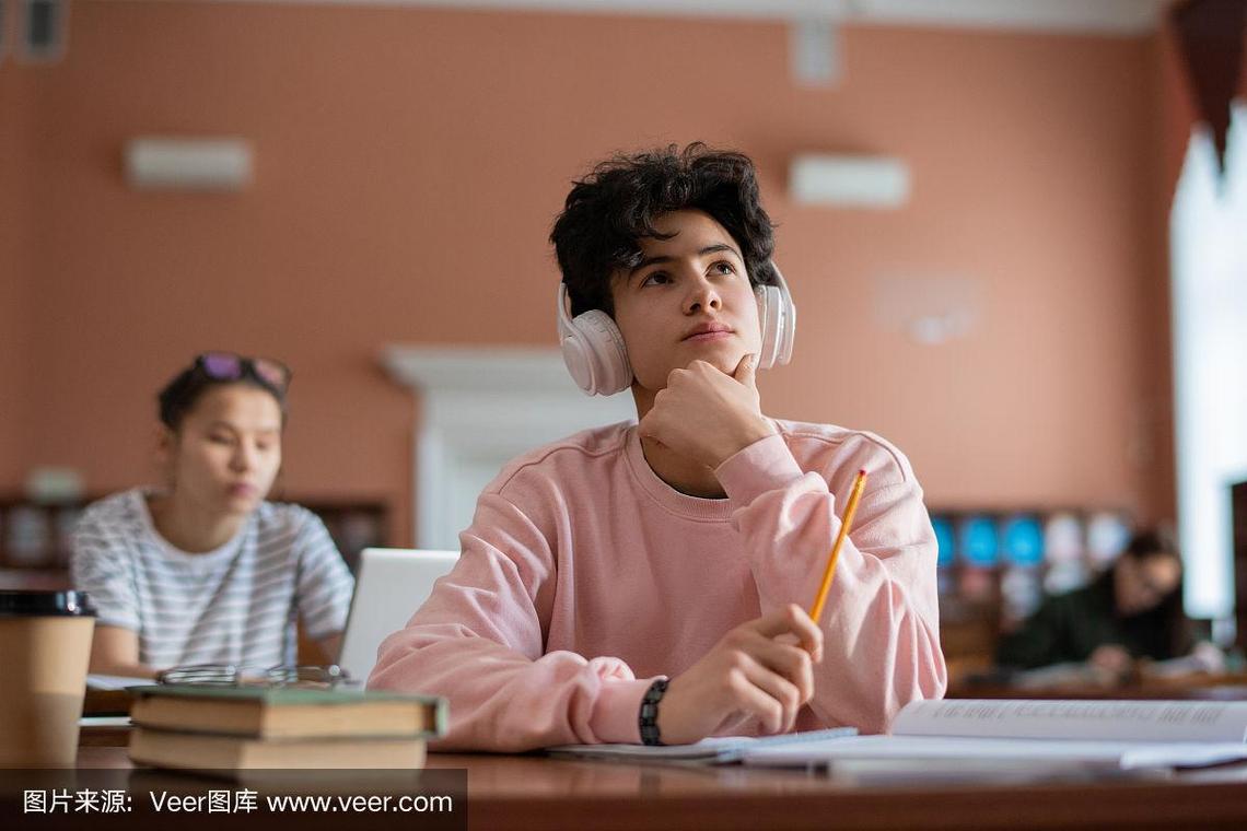 图书馆窗边学生戴着耳机休息的场景