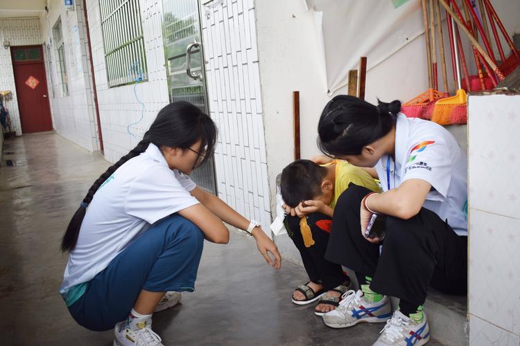 小学班主任蹲身平视和掉眼泪的学生交流场景