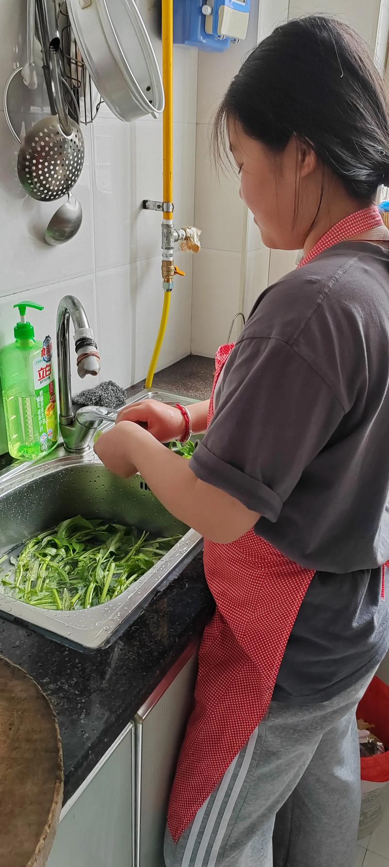幼儿在厨房帮大人洗菜的实拍