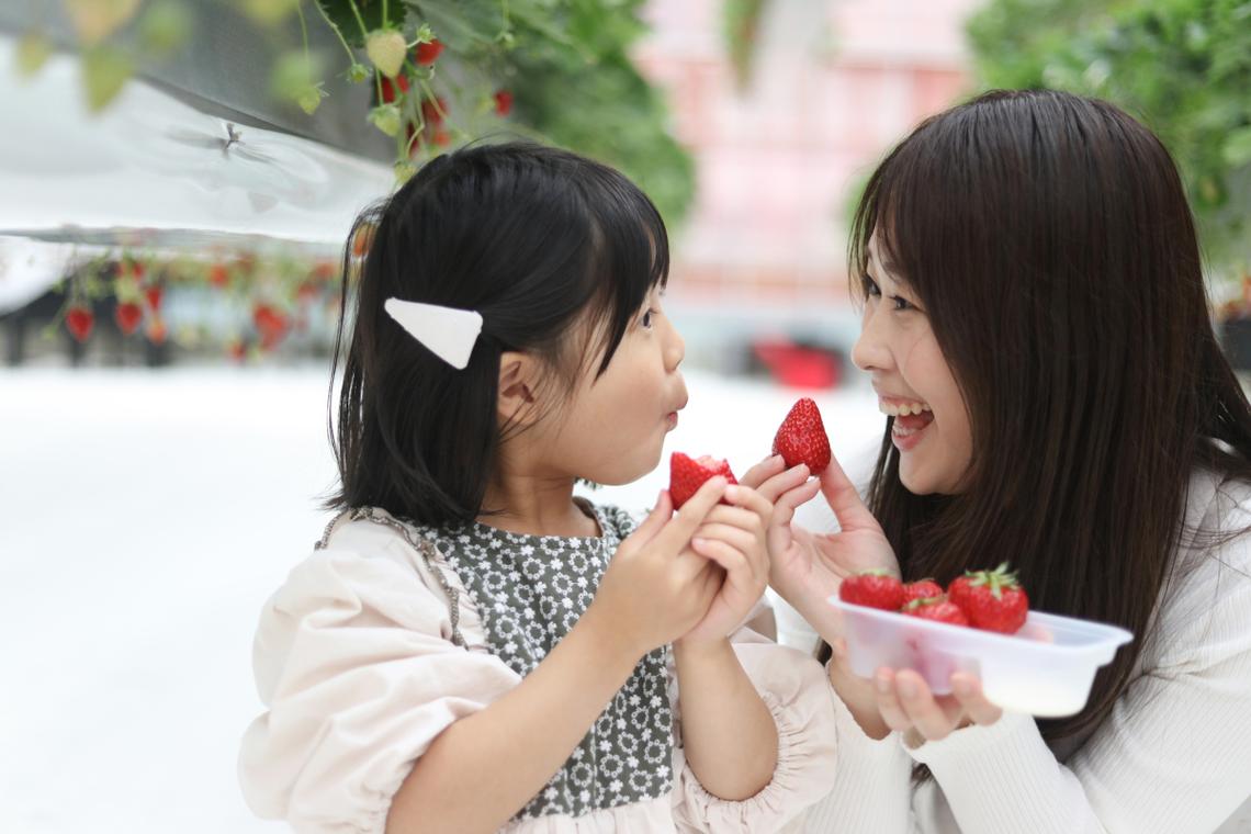 妈妈微笑看着孩子吃苹果