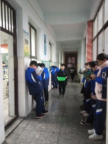 小学走廊靠墙低头站着的学生
