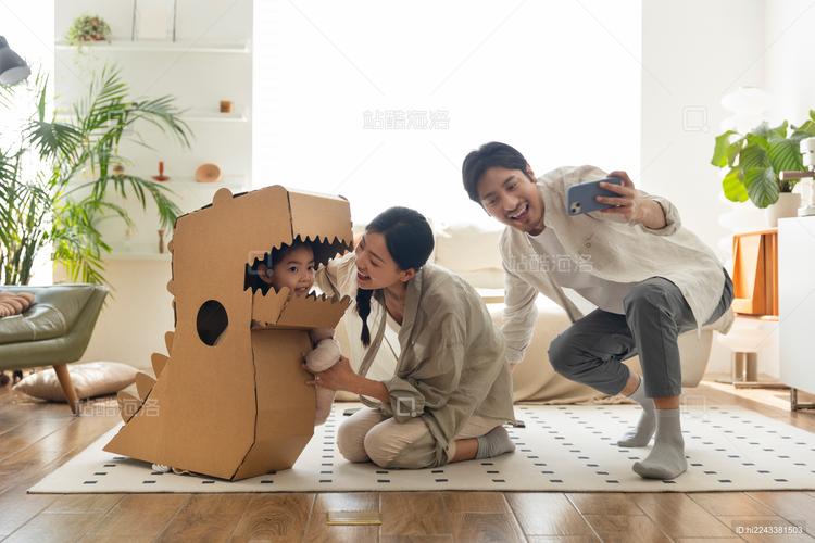 客厅地板上亲子一起做纸箱恐龙手工场景
