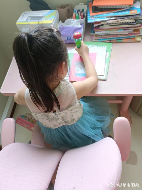 小女孩拿着双面胶蹲在教室墙报角落
