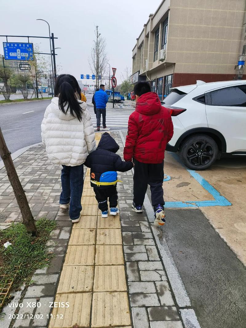 工业园区职工家属日俩孩子牵手等候照片