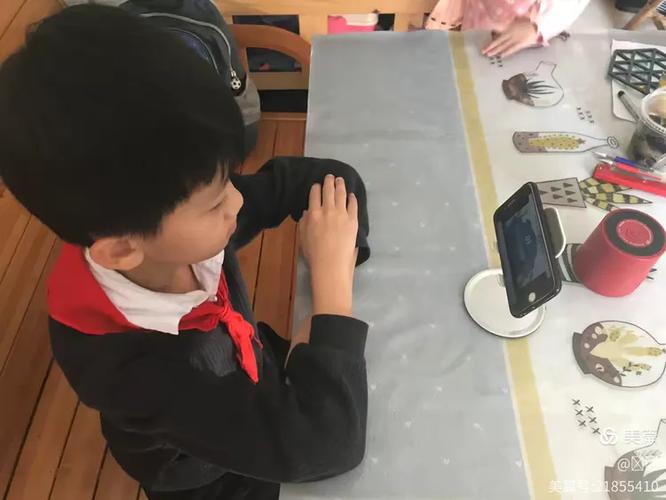 小学老师课间蹲在教室门口和拿奥特曼画本的小男孩聊天