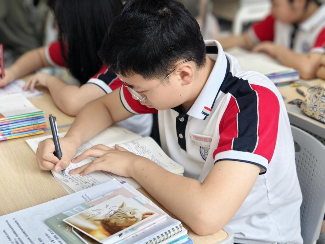 初中教室课桌上学生低头刷预习网课视频的场景