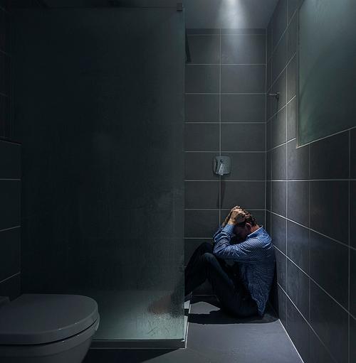 一个男人在淋浴间闭眼思考创意 水流