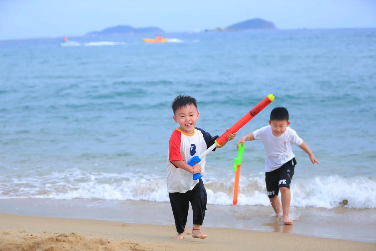 两岁孩子在海边踏浪欢笑的背影