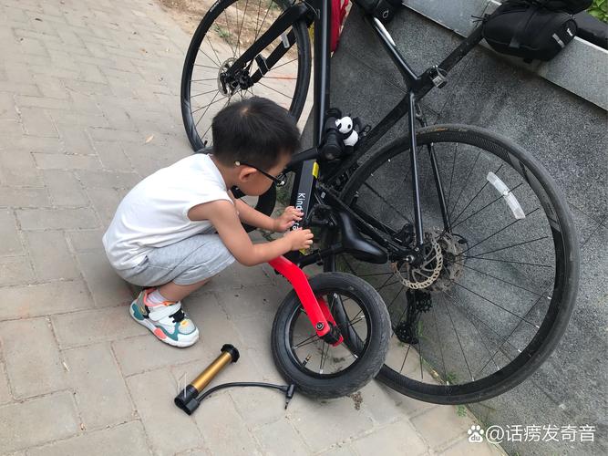儿童蹲在地上拆解旧自行车的日常实拍图