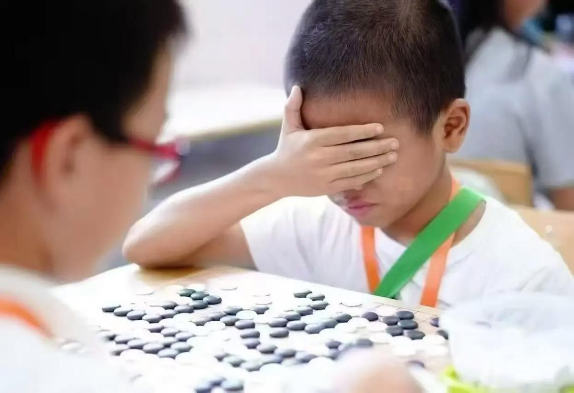 孩子输棋懊恼推棋盘表情特写
