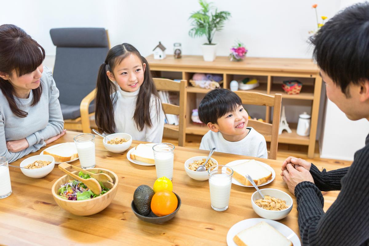 家庭餐桌幼儿自己吃饭的温馨场景图