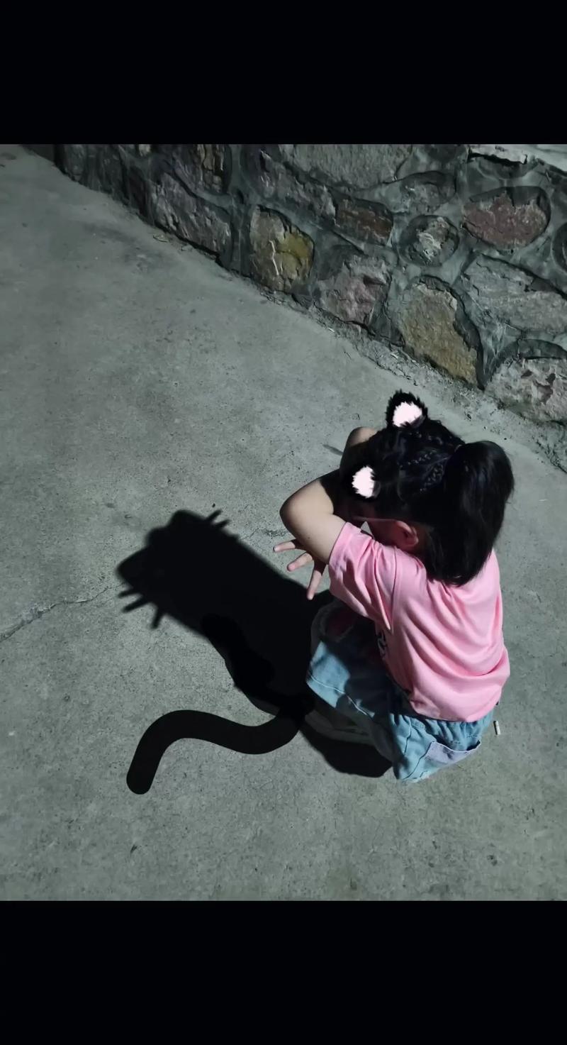 孩子蹲在路灯下观察自己影子的夜晚特写