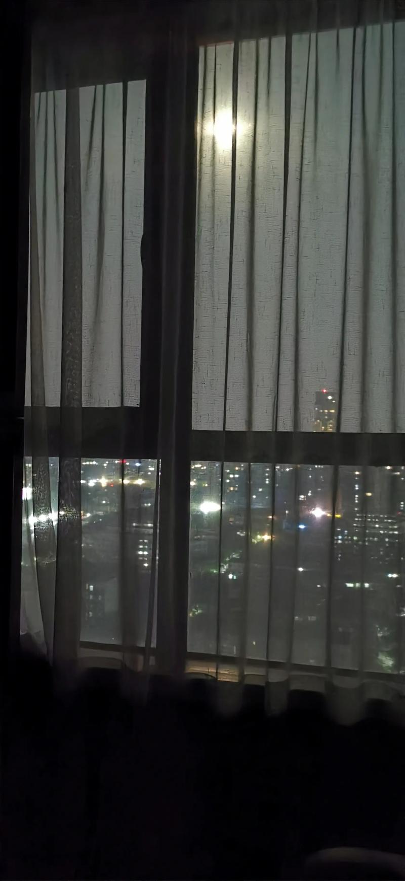 深夜手机屏幕映照着脸的窗户玻璃反光
