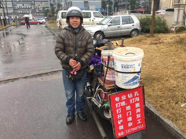 城市小学门口路边蹲着等活的装修工人